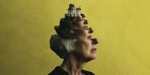 A vibrant theatre stage with red curtains, spotlight illuminating performers in colourful costumes during a dramatic scene.