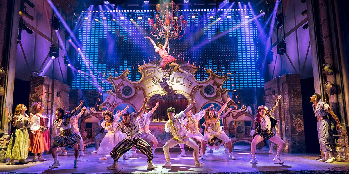 Cassidy Janson, Melanie La Barrie, Miriam-Teak Lee, Arun Blair-Mangat, and ensemble members pose together smiling.