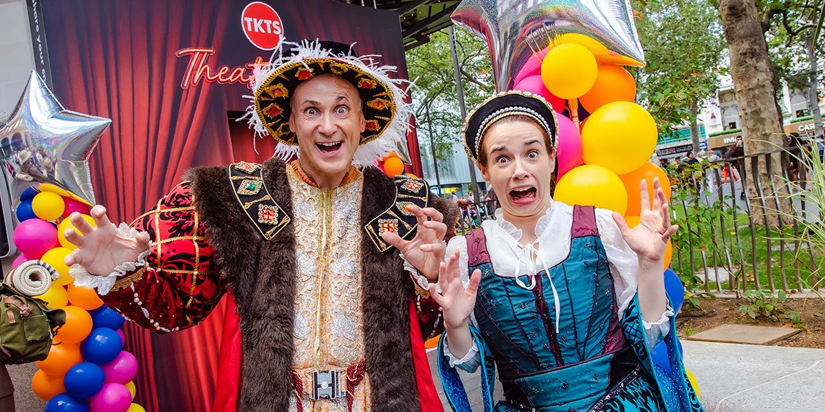 Two people in Tudor dress look scared towards the camera