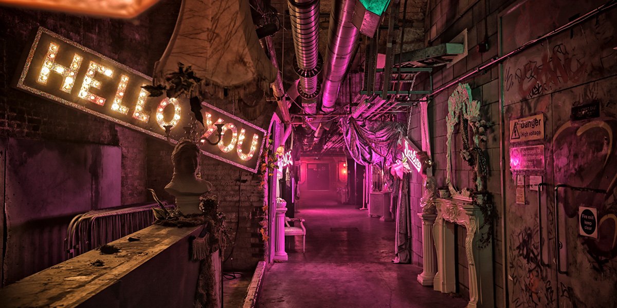 The Vaults Theatre interior featuring exposed brick walls, dim lighting, and a wooden stage with seating.